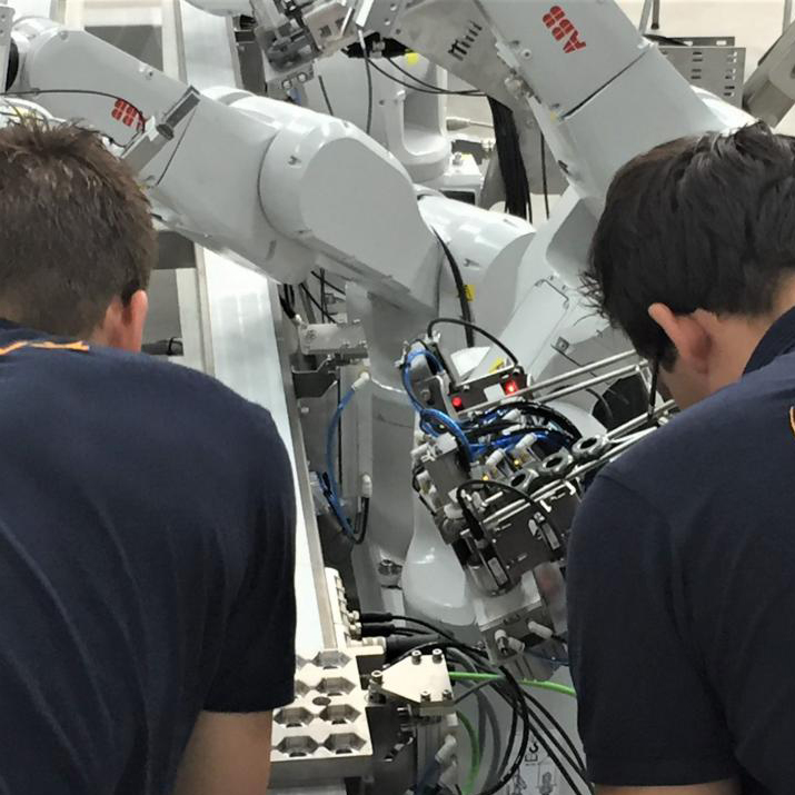 2 mannen sleutelen aan een robot